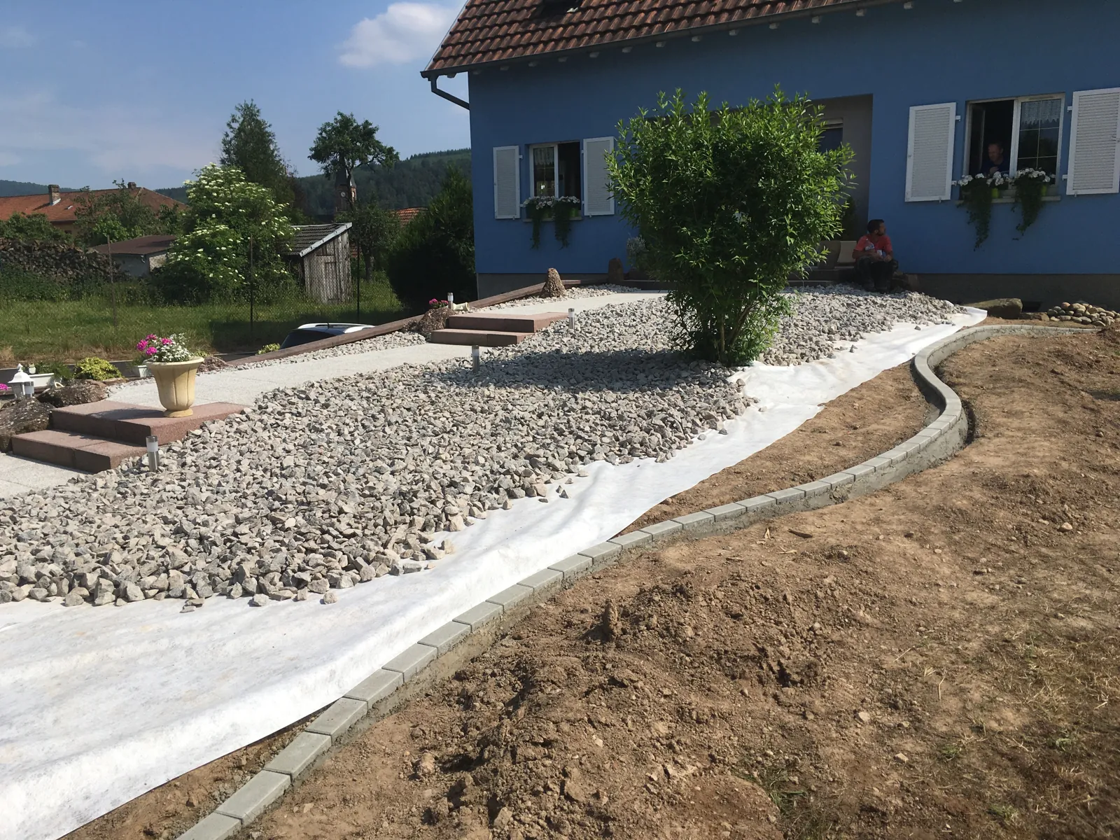 Massif minéral et cheminement devant une maison à Urmatt