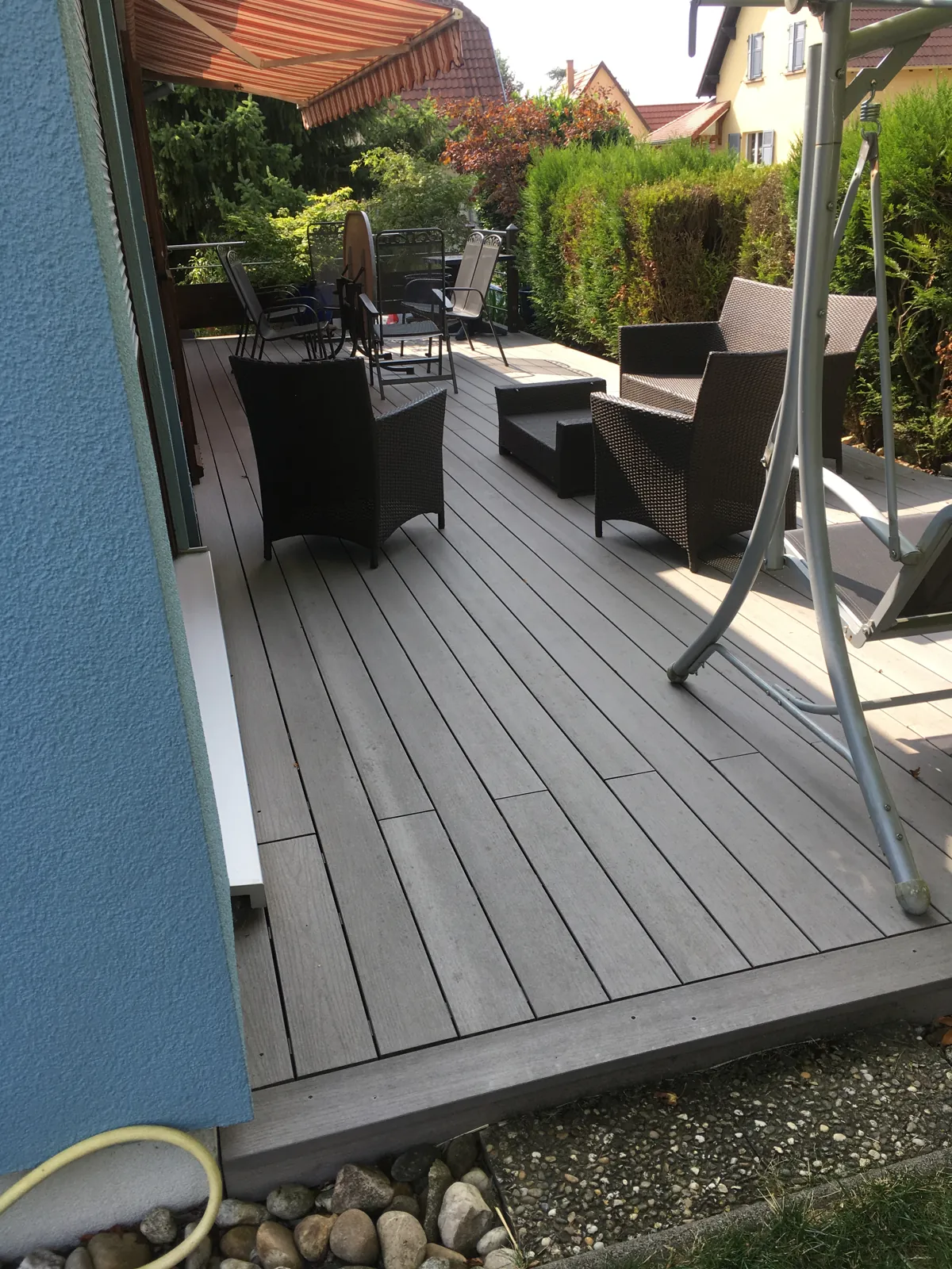 Terrasse en lames le long d’une maison et de ses plantations